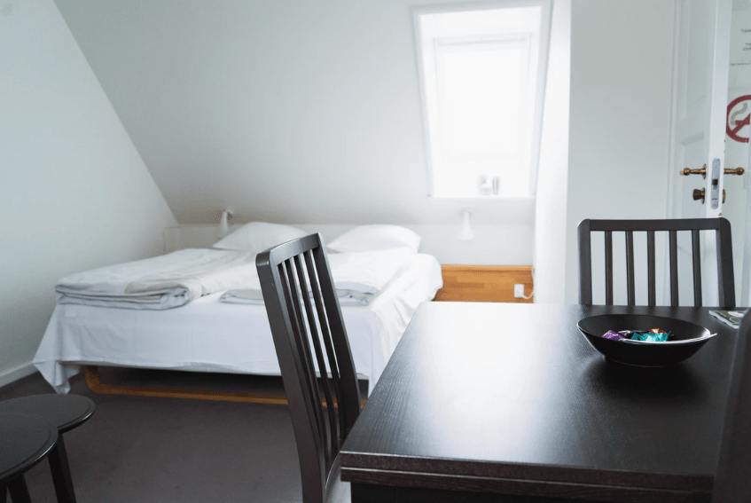 billede af soveværelse i lejligheden med sort spise bord og ovenlys vinduer
